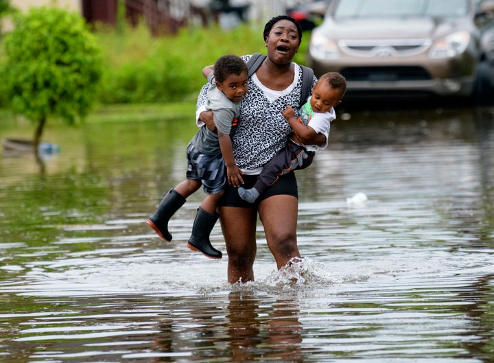 Terrian Jones reacts as she feels something moving in the water at her feet as she carries Drew and Chance Furlough to their