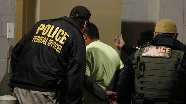 U.S. Immigration and Customs Enforcement agents escort a man to lockup during a raid in Richmond, Virginia, last year. The Trump administration has announced plans to deport immigrants under orders of removal.
