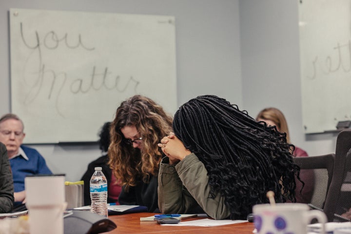 Employees at Miracle Hill Ministries pray during a meeting. The federally funded agency limits its hiring to Christians.