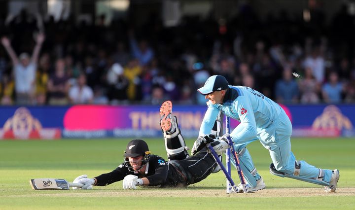 England's Jos Buttler runs out New Zealand's Martin Guptill during the Super Over in the Cricket World Cup final match.