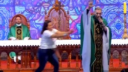 Una mujer empuja a un sacerdote en plena