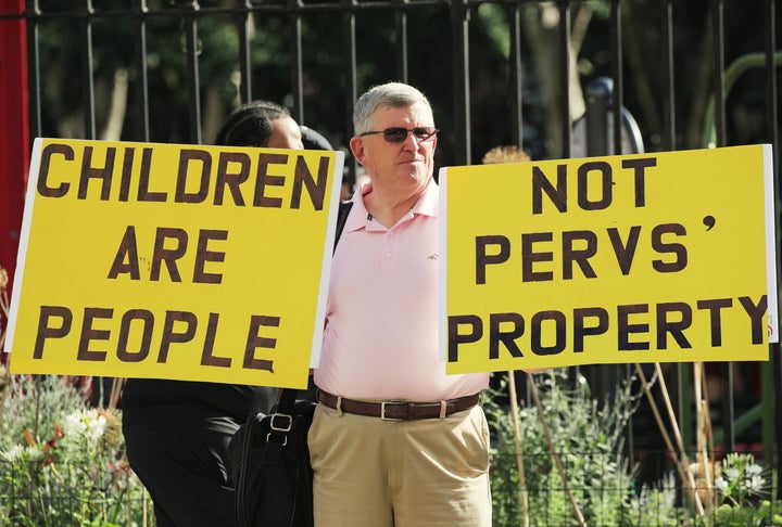 A protester holds up signs outside the courthouse ahead of a bail hearing in U.S. financier Jeffrey Epstein's sex trafficking