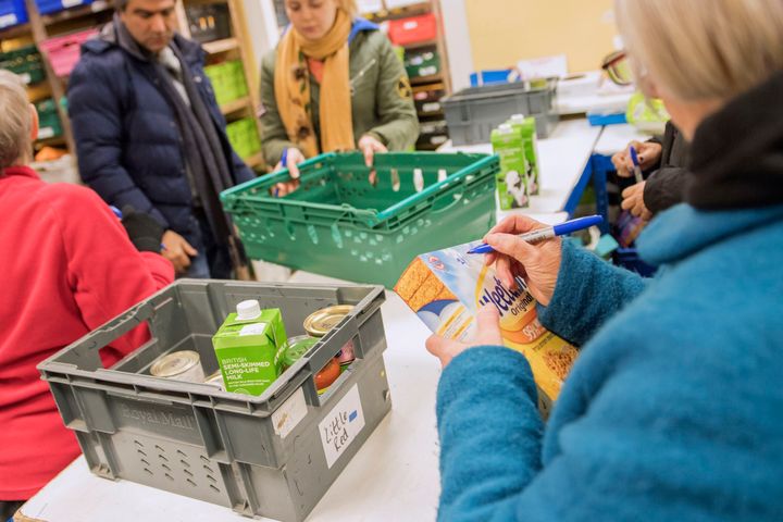 Foodbank volunteers sort through donations at a warehouse.