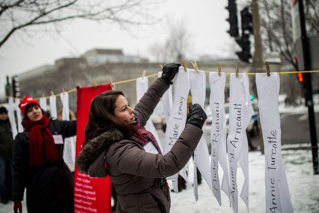 People put papers that bear the names of the victims of the Ecole Polytechnique massacre in Montreal, Canada on Dec. 6, 2014. 
