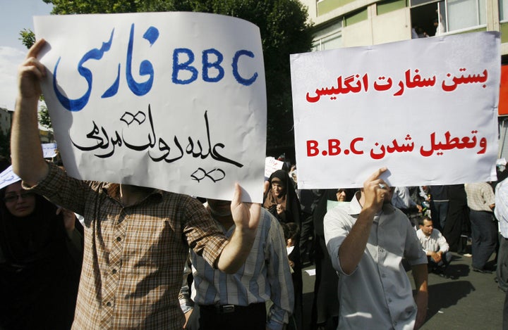 Supporters of President Mahmoud Ahmadinejad hold up placards against the British media during a rally in Tehran's Vali Asr Square on June 16, 2009. The rally, called by the Islamic Propagation Council, was staged at the same time as a rival gathering by supporters of defeated candidate Mir Hossein Mousavi. Farsi slogans read: "Closing the British Embassy and BBC," right, and "Persian BBC against the Iranian government." 