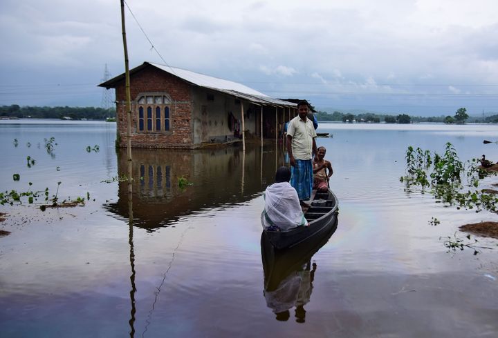 Villagers are transported on a boat towards a safer place at a flooded village in Nagaon district, in Assam, India July 15, 2019. 
