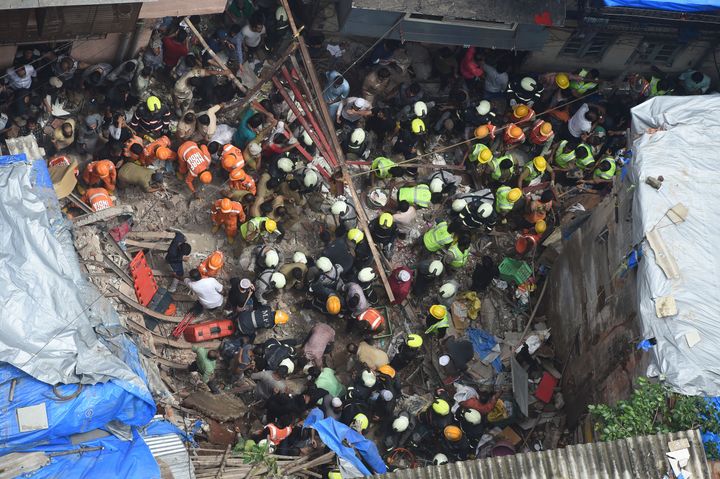 Fire brigade personnel and rescue workers look for survivors after a building collapsed in Mumbai on July 16, 2019. 