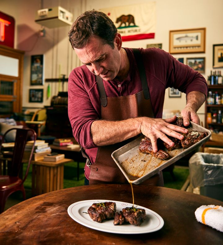 Chef Adam Perry Lang pours a post-marinade over seared meat.