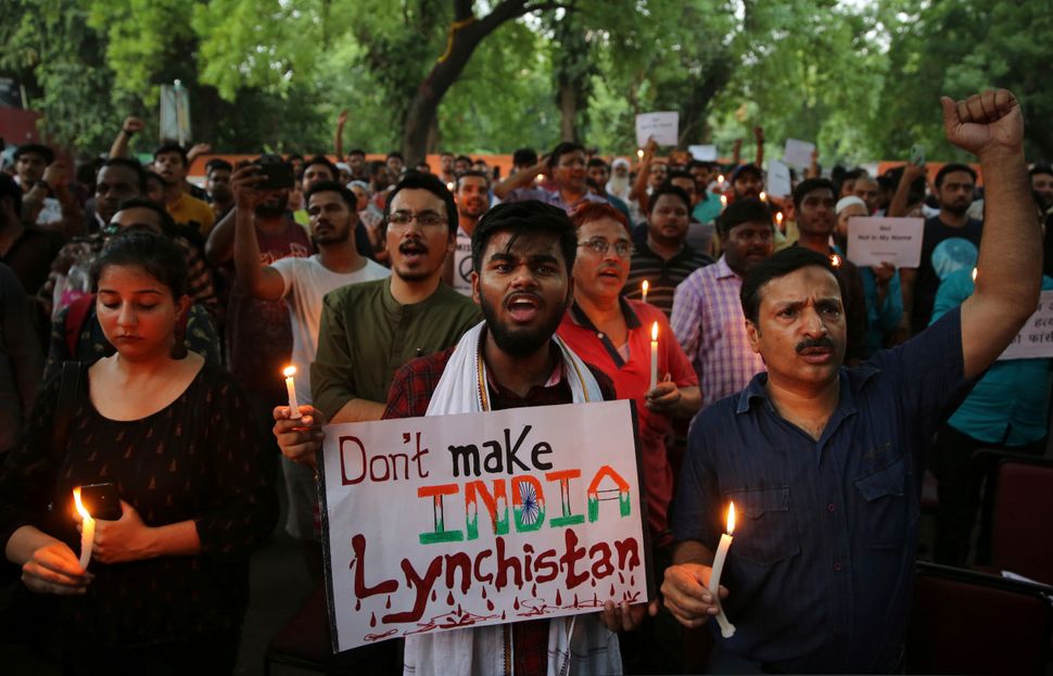 protesters shout slogans as they hold placards and candles during a protest condemning recent mob lynching of Muslim youth Tabrez Ansari in Jharkhand state, in New Delhi, India, Wednesday, June 26, 2019