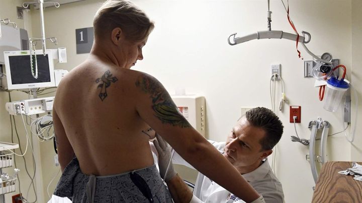 A doctor prepares a patient for a bilateral mastectomy at a Boston hospital. Massachusetts is among a dozen states that have adopted measures to prohibit gender identity discrimination by health care providers, while the Trump administration seeks to remove Obama-era protections for transgender-related health care services.