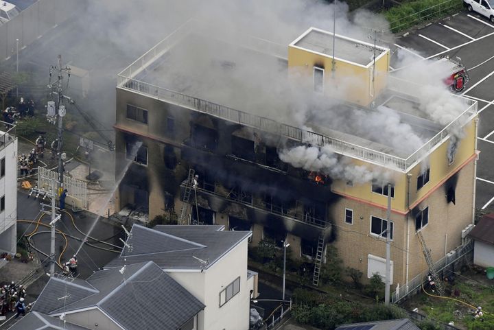 An aerial view shows firefighters battling fires at the site where a man started a fire after spraying a liquid at a three-story studio of Kyoto Animation Co. in Kyoto, July 18, 2019. 