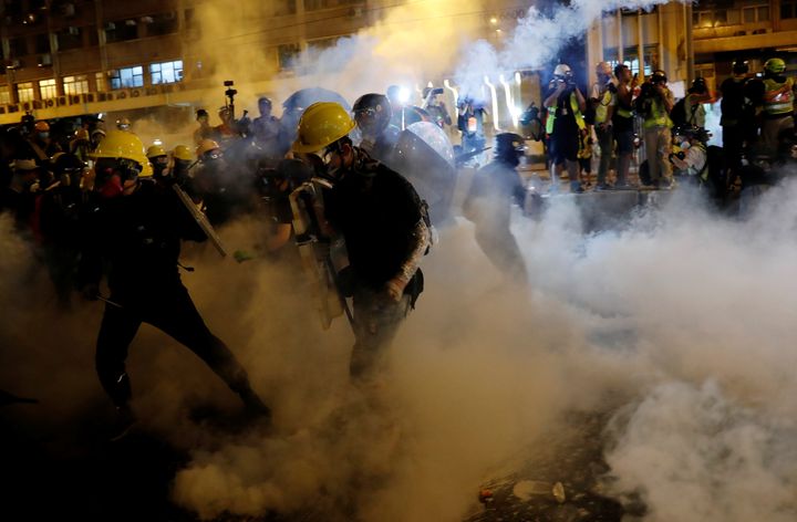 Anti-extradition demonstrators run from tear gas after a march of to call for democratic reforms, in Hong Kong