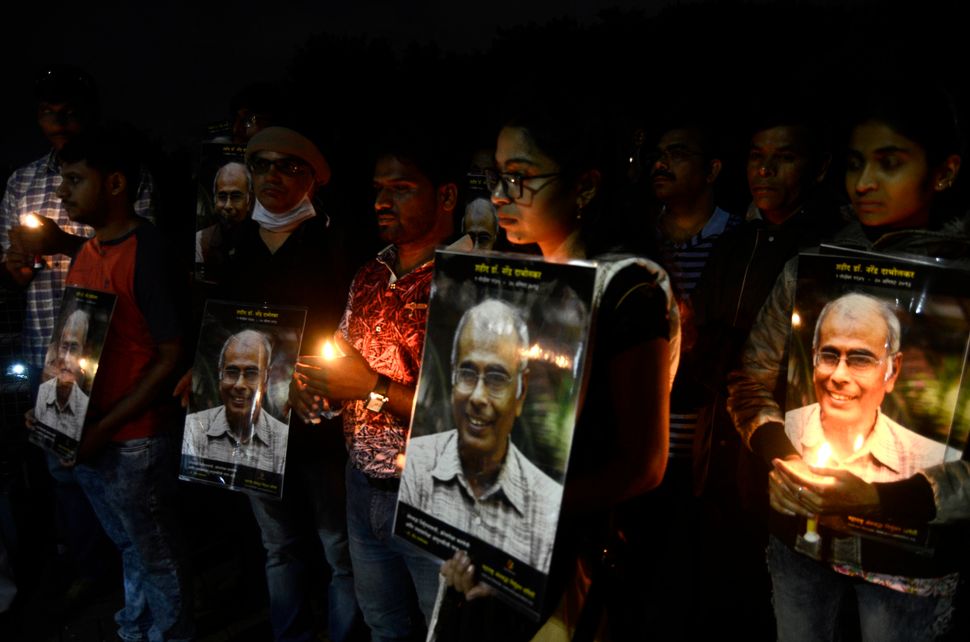Andhashraddha Nirmoolan Samiti volunteers light up candles on the eve of fifth death anniversary of Dr. Narendra Dabholkar at Shinde Bridge, on August 19, 2018 in Pune. Narendra Dabholkar, who was founder of the Maharashtra Andhashraddha Nirmoolan Samiti, was shot dead in Pune on 20 August 2013. 
