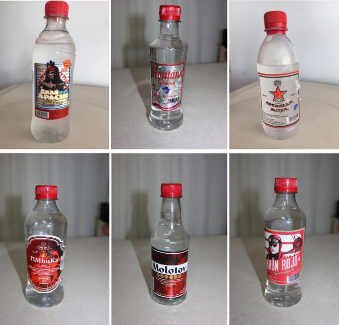 Products with labels reading "Guaro Gran Apache," "Red Star Brandy," "Guaro Montano," " Aguardiente Barón Rojo," " Agu