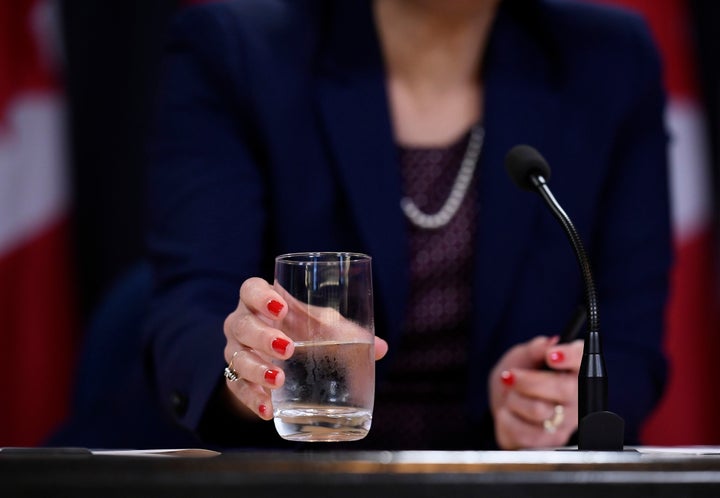 Health Minister Ginette Petitpas Taylor drinks from a glass of water during a press conference at the National Press Theatre in Ottawa on July 22, 2019.