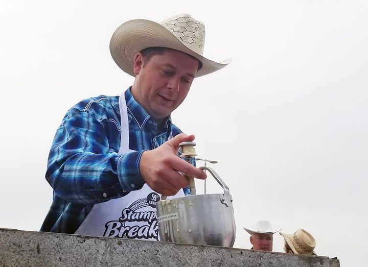 Conservative Leader Andrew Scheer makes pancakes at a pancake breakfast as part of the Calgary Stampede in Calgary on July 6, 2019.