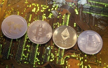 Representations of the Ripple, Bitcoin, Etherum and Litecoin virtual currencies are seen on motherboard...