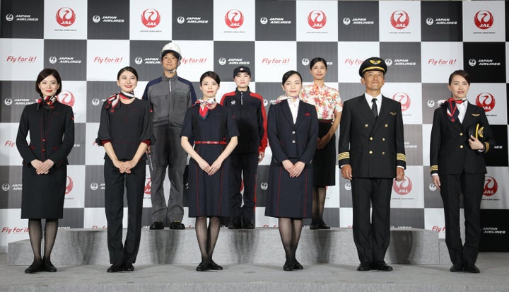 新制服を披露する日本航空(JAL)の客室乗務員ら=23日、東京都大田区。左から2番目の女性が着用しているのが、女性の客室乗務員に新たに採用されたパンツスタイルだ。