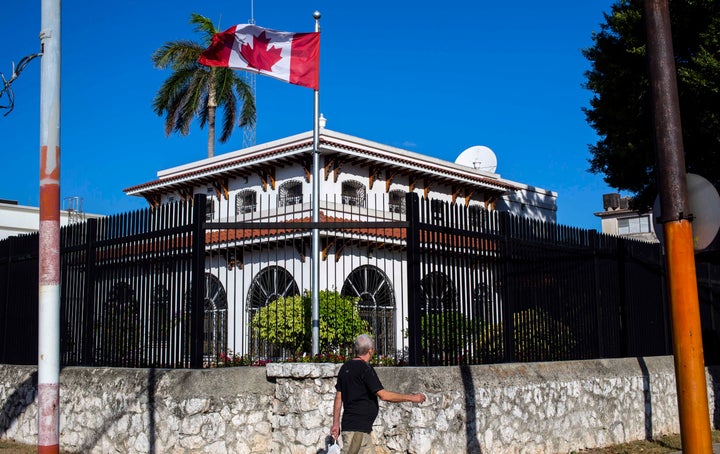 In this April 17, 2018 file photo, a man walks beside Canada's embassy in Havana, Cuba. Some Canadian diplomats who became mysteriously ill while posted to Cuba are suing the Canadian government.