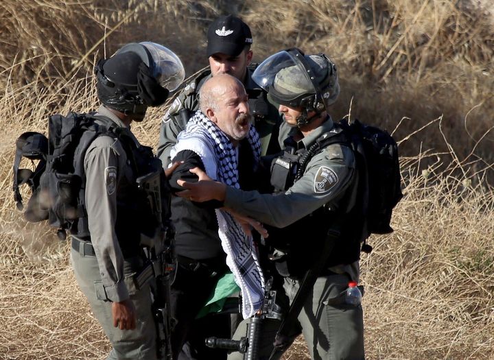 Ισραηλινοί στρατιώτες εμποδίζουν Παλαιστίνιο να προσεγγίσει την περιοχή όπου οι αρχές του Ισραήλ κατεδαφίζουν σπίτια Παλαιστινίων. 