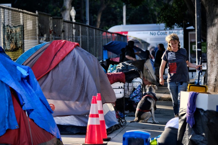 Homeless people move belongings from a street near Los Angeles City Hall as crews prepared to clean the area on Monday, July 1, 2019.