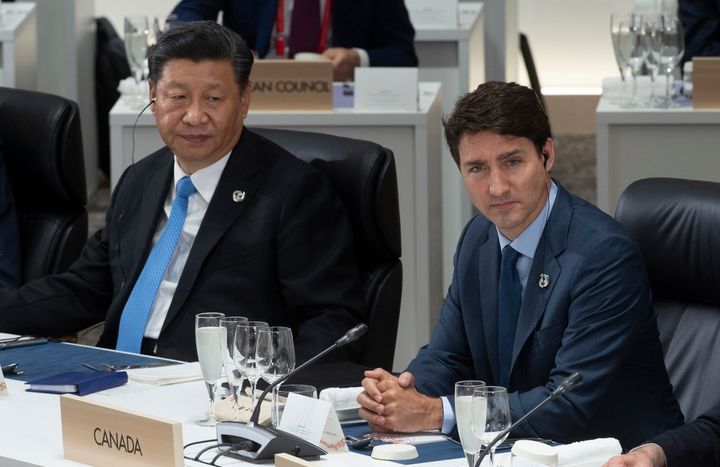 Chinese President Xi Jinping and Prime Minister Justin Trudeau listen to opening remarks at a plenary session at the G20 Summit in Osaka, Japan on June 28, 2019.