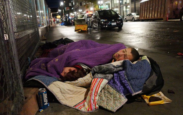 A couple sleeps on a street in downtown Portland, Oregon, in 2017. An analysis found that one in every two arrests made by the Portland Police Bureau in 2017 was of a homeless person.
