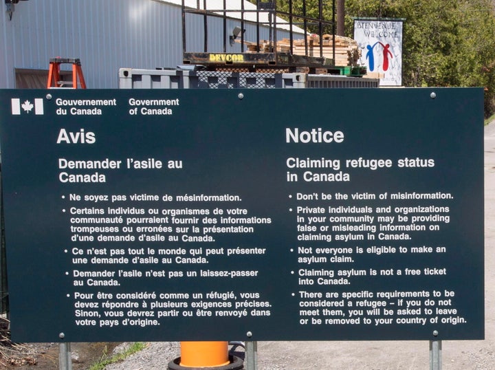 A sign warning asylum seekers is seen at the Canada-U.S. border at Roxham Road on May 9, 2018 in Champlain,NY.