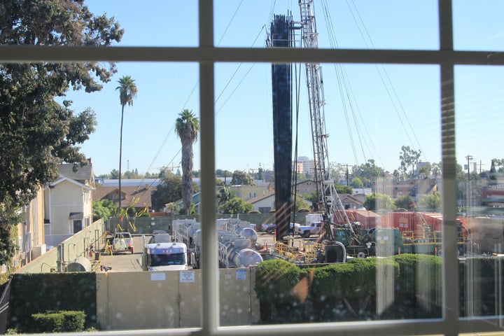 The Jefferson Boulevard drill site seen through a window of a neighboring home. In some places, the site is just feet from occupied houses.