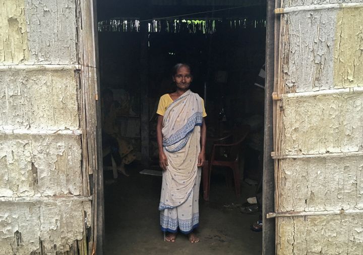 Madhubala Mandal, 59, poses for a photograph inside her bamboo hut in Bishnupur village in Assam.