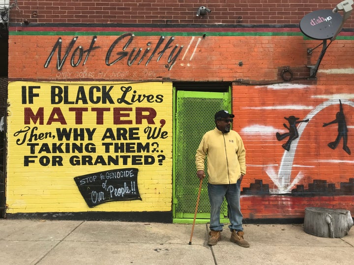 Byron Mischeaux stands in front of his barbecue restaurant in St. Louis. He says he painted these murals after he survived being shot in the head three times.