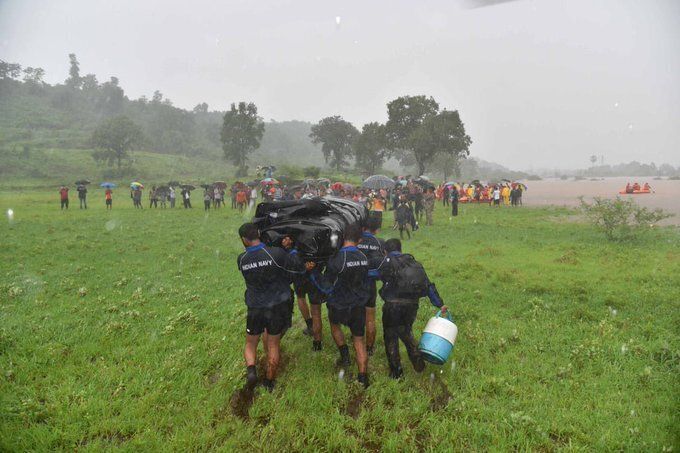 Indian Navy personnel carry boats to the rescue site.