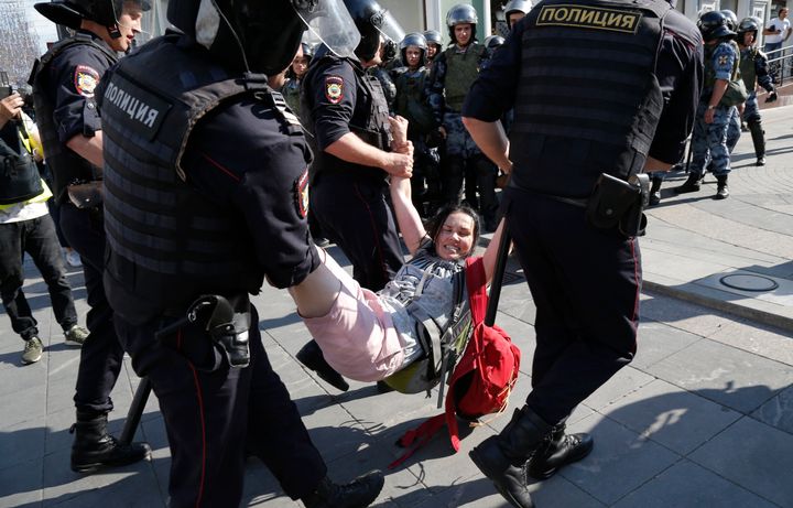 Police officers detain a woman during an unsanctioned rally in the center of Moscow, Russia, Saturday, July 27, 2019. Russian police are wrestling with demonstrators and have arrested hundreds in central Moscow during a protest demanding that opposition candidates be allowed to run for the Moscow city council. (AP Photo/Alexander Zemlianichenko)