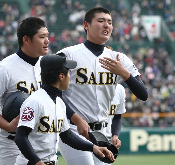 浦和学院に敗れ、応援スタンドにあいさつを終え、ベンチに引き揚げる済美の安楽智大投手（右）＝2013年4月3日、甲子園球場