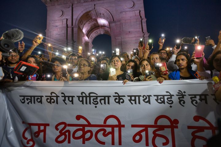 People use their mobile phones as torches while gathered for a silent protest in solidarity with the Unnao rape case victim, at India Gate on July 29, 2019 in New Delhi. 