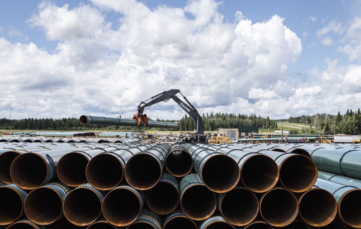 Des tuyaux pour la construction du pipeline Trans Mountain sont déchargés à Edson en Alberta, le 18 juin 2019.