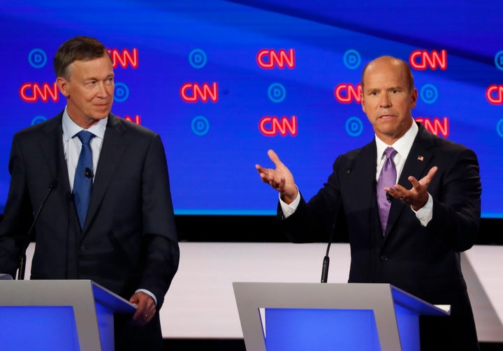 Former Colorado Gov. John Hickenlooper (left) looks on as fellow centrist John Delaney, a former Maryland congressman, speaks at Tuesday's debate among 10 Democratic presidential candidates in Detroit.