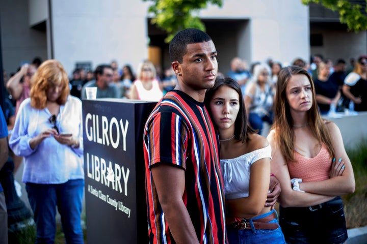 Derrick Smith, left, embraces Sara Sakamoto during a vigil for victims of Sunday's deadly shooting at the Gilroy Garlic Festi