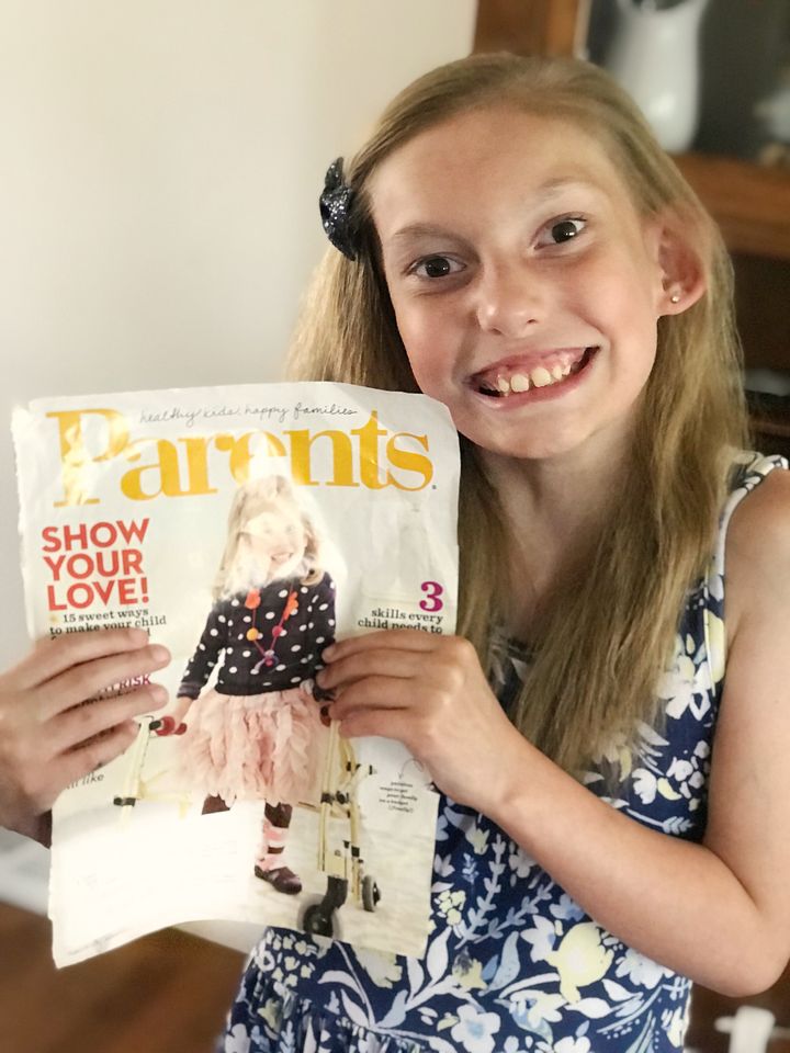 Evalyn in 2019, now 8 years old, holding the special magazine cover.