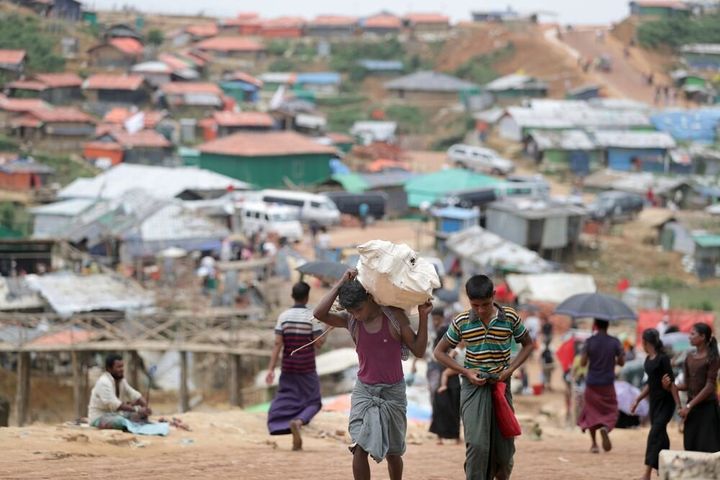 食料や住宅用資材を運ぶ難民たちが行き交う＝2018年8月、バングラデシュ南東部コックスバザール、朝日新聞社撮影