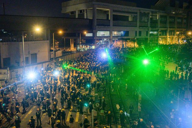 Protesters use laser lights as they move back to Yuen Long MTR station after a protest in Hong Kong on July 27, 2019