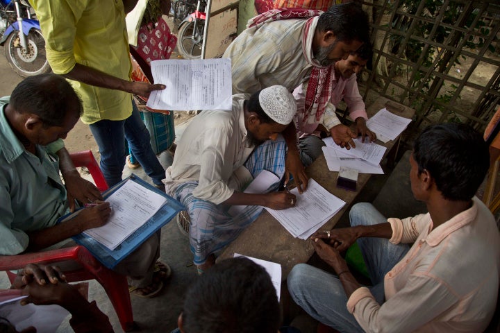 People whose names were left out in the National Register of Citizens draft fill their forms to file appeals near a NRC center on the outskirts of Guwahati, Aug. 13, 2018.