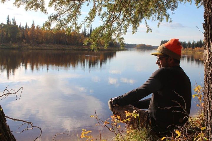 Author Adrian Sutherland sits along the Attawapiskat River.
