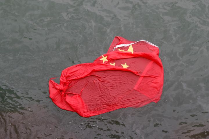 A Chinese flag floats on the surface it was thrown in the water by protesters during a demonstration in Hong Kong on Saturday.