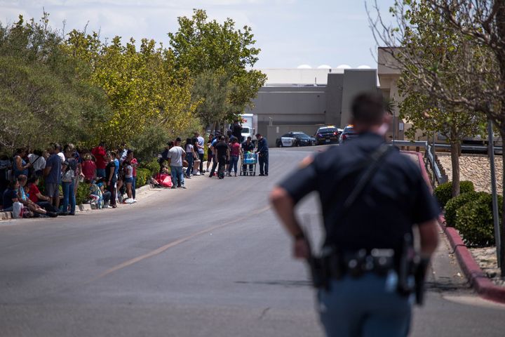 Evacuated people sit outside the Walmart in El Paso, Texas, on Saturday after the mass shooting that claimed at least 20 lives.