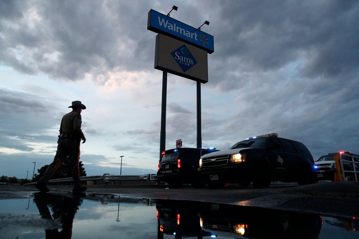 Law enforcement officials block a road early Sunday morning at the scene of a mass shooting that occurred Saturday at a shopping complex in El Paso.