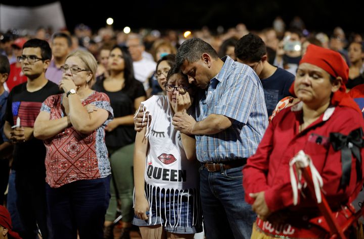 People comfort each other during a vigil for victims of Saturday's mass shooting in El Paso, Texas