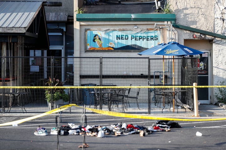 Shoes are piled outside the scene of a mass shooting including Ned Peppers bar, Sunday, Aug. 4, 2019, in Dayton, Ohio.