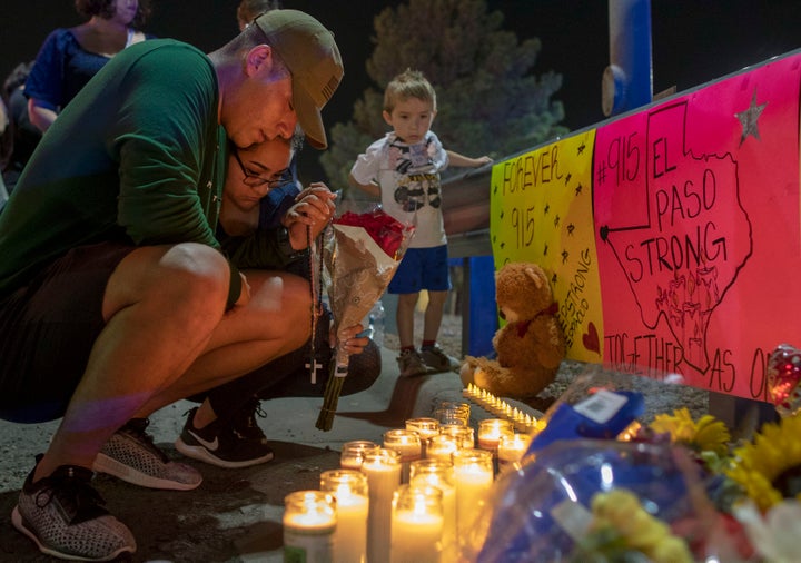 Rene Aguilar and Jackie Flores pray at a makeshift memorial for the victims of Saturday's mass shooting in El Paso, Texas, on