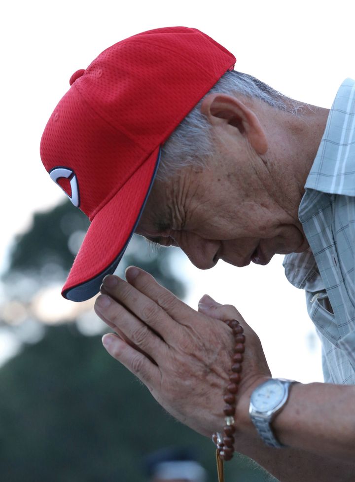 広島原爆の日を迎え、原爆死没者慰霊碑の前で手を合わせる男性（広島市中区の平和記念公園）